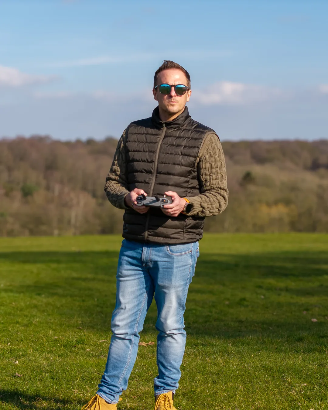 Matt Barker, founder of SkyHi, holding a drone controller in a field