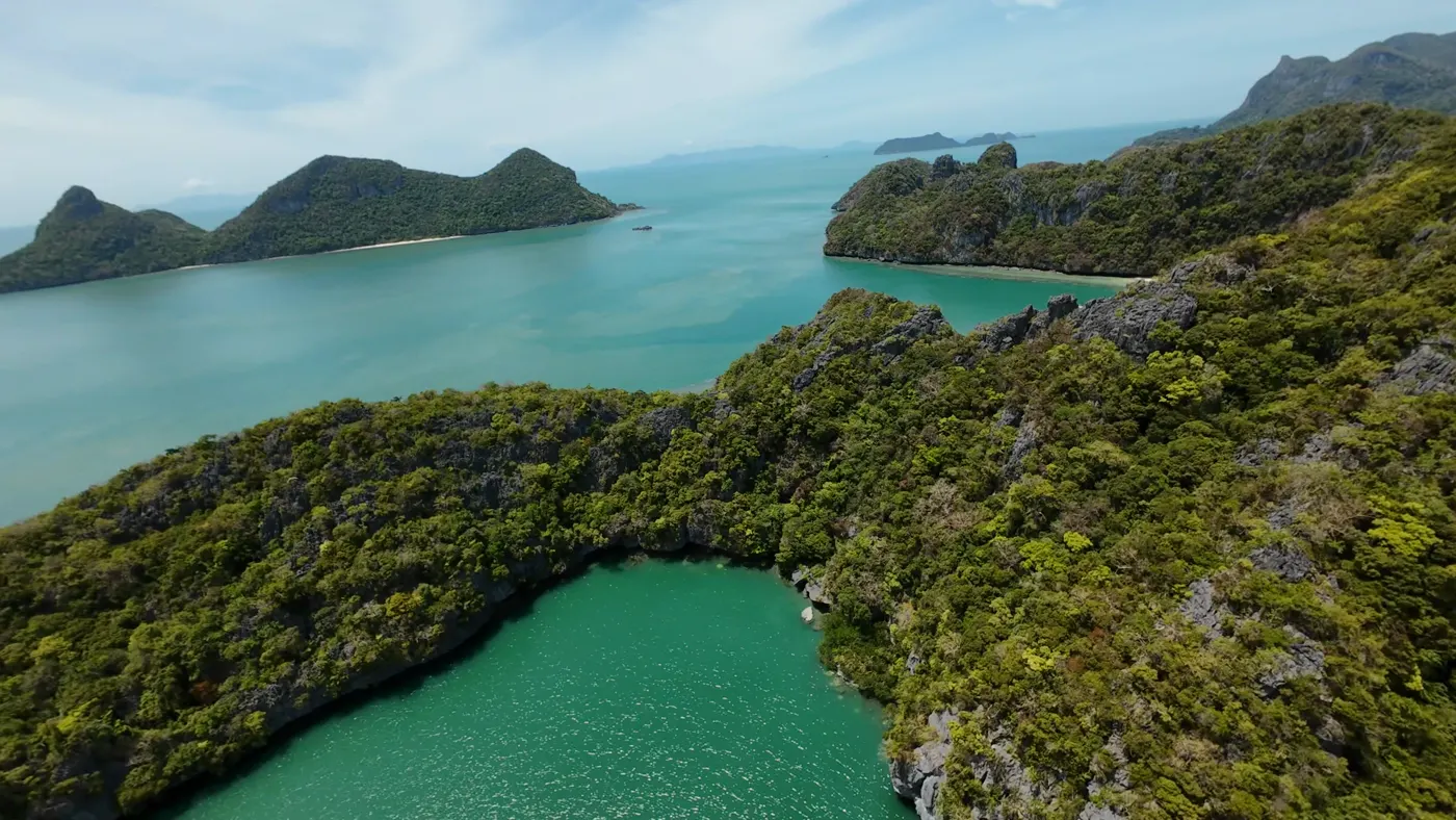 Emerald saltwater lagoon enclosed by jungle-covered limestone walls