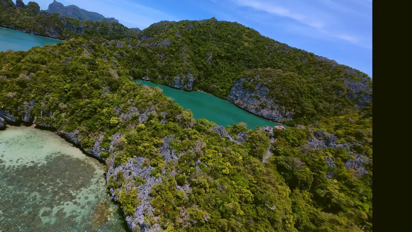 Aerial view of jungle-covered islands, a hidden lagoon and shallow reef