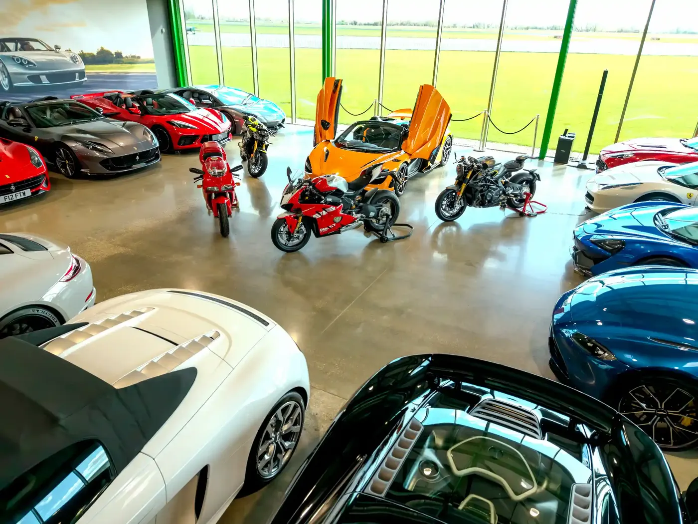 Wide view of the DMB Collection showroom floor with supercars and sports bikes
