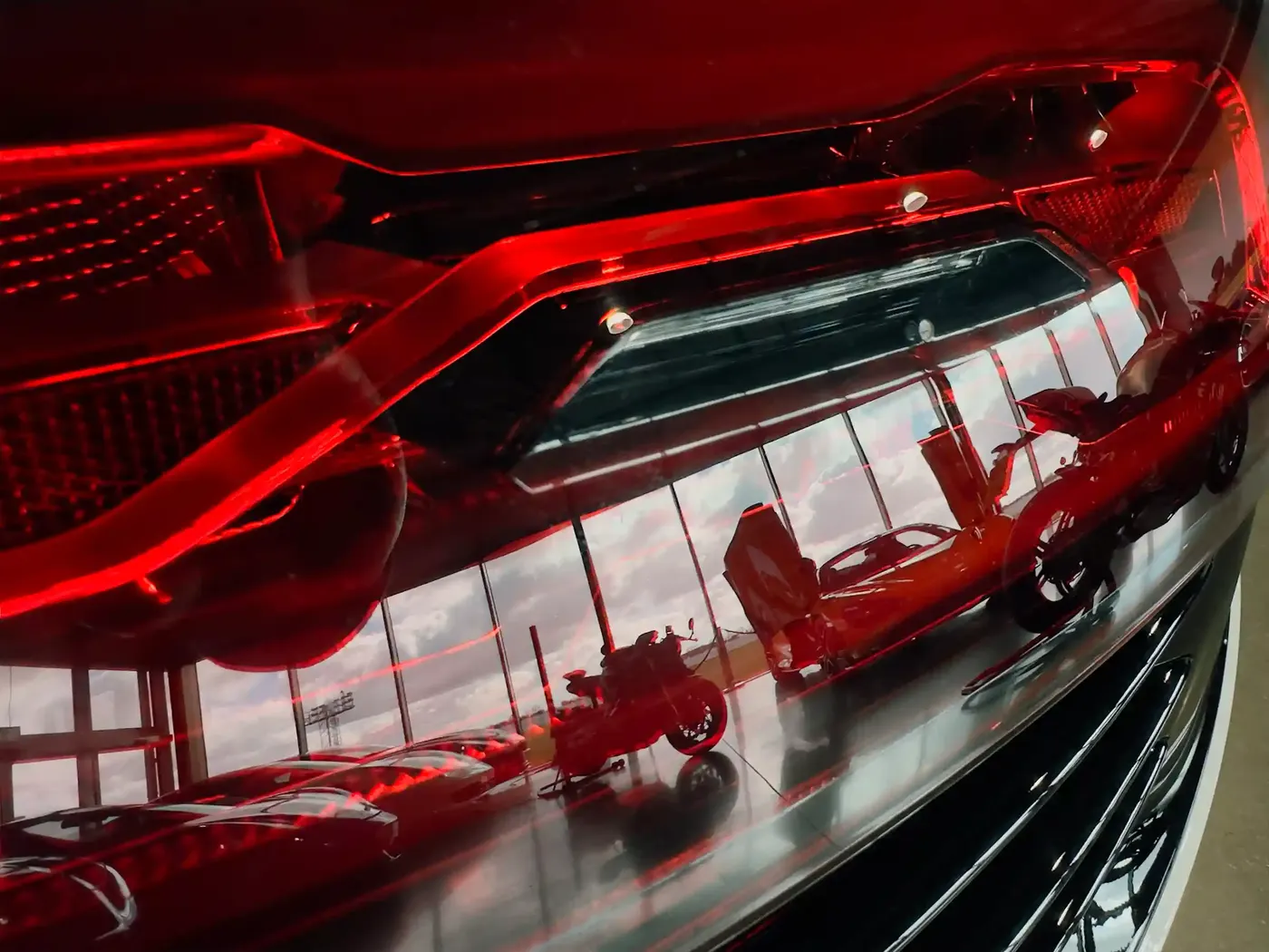 Red supercar light cluster reflecting the showroom windows