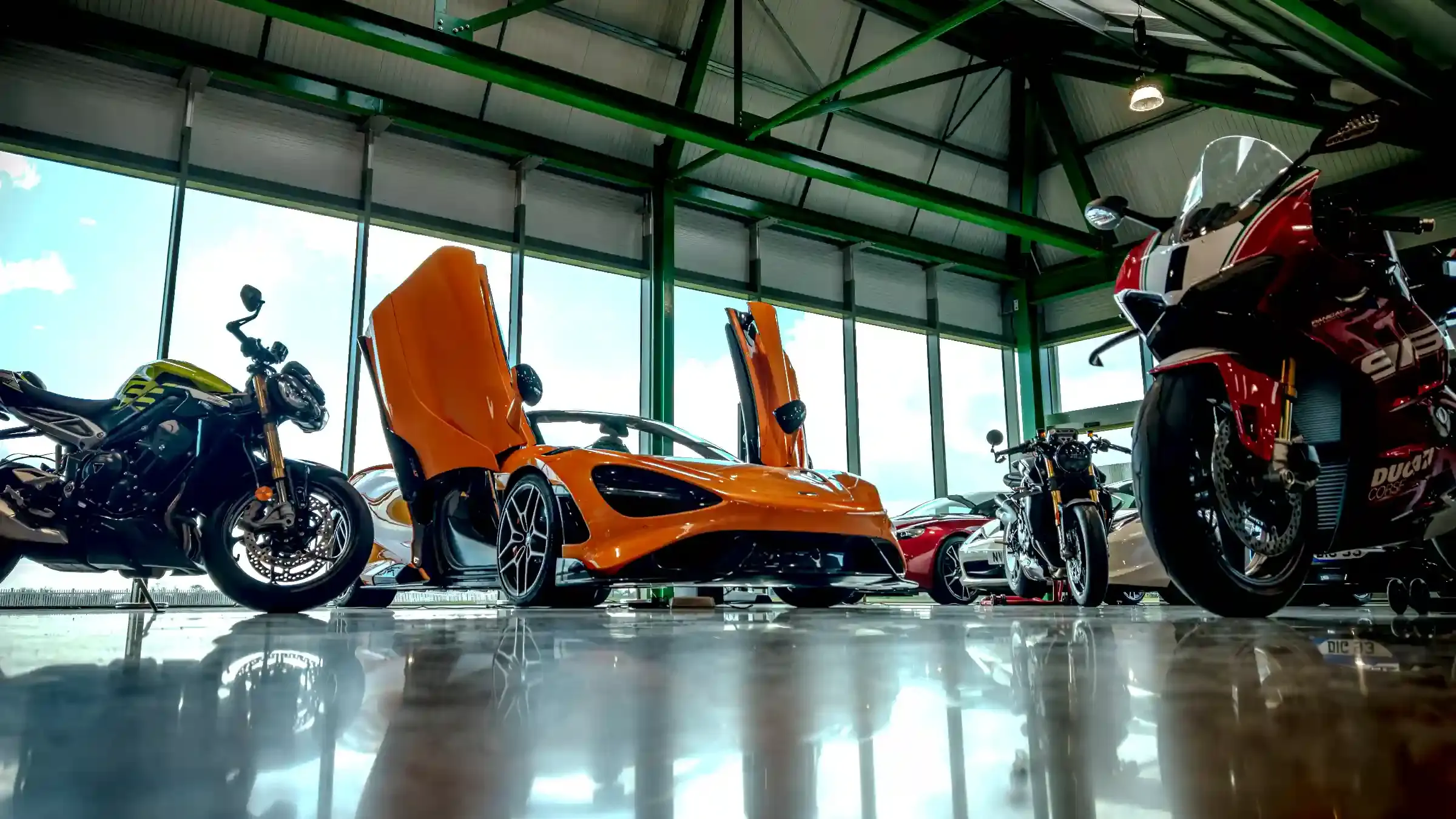 McLaren and Ducati sports bikes lined up in the showroom